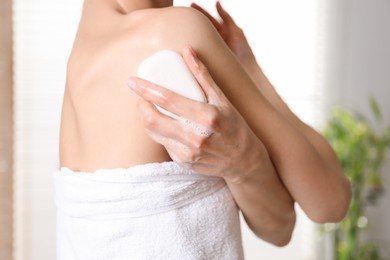 Photo of Woman with soap bar in bathroom, closeup