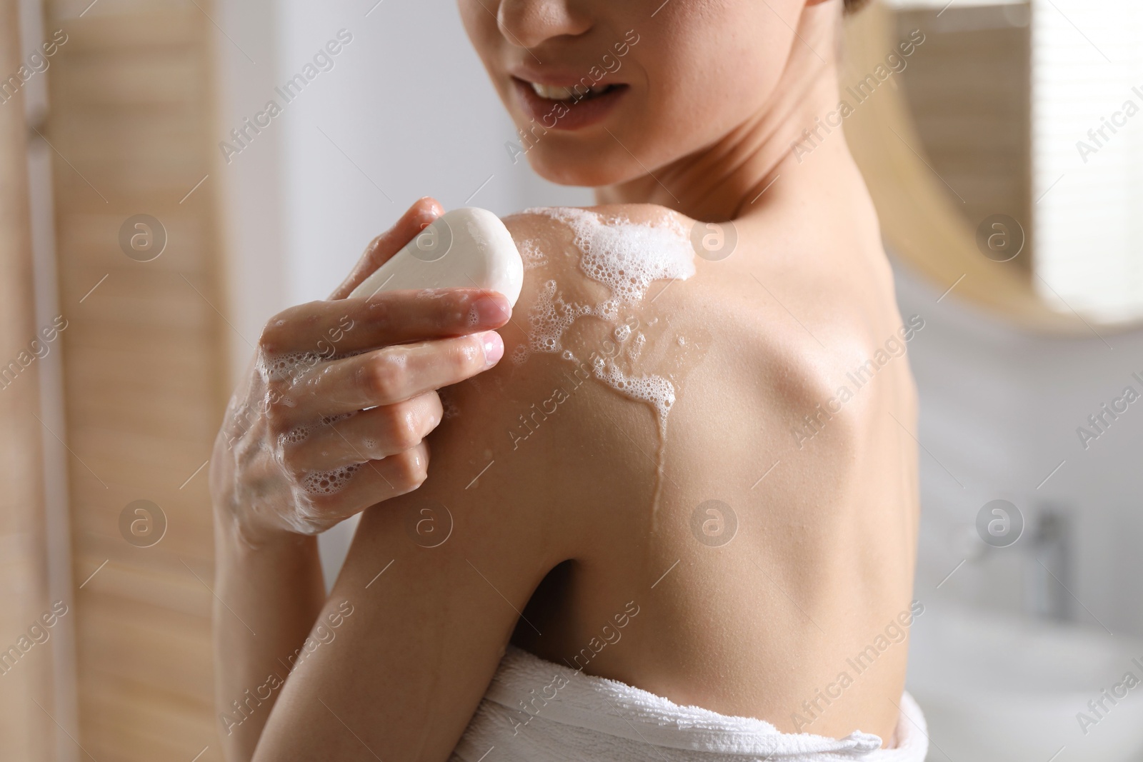 Woman washing body with soap bar indoors, closeup Photo of Woman washing body with soap bar indoors, closeup