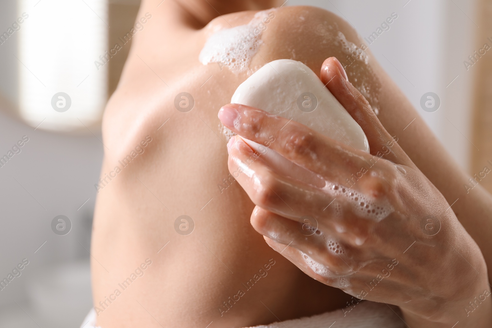 Woman washing body with soap bar indoors, closeup Photo of Woman washing body with soap bar indoors, closeup
