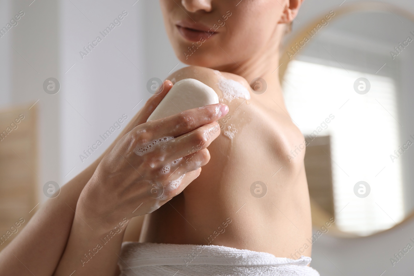 Woman washing body with soap bar indoors, closeup Photo of Woman washing body with soap bar indoors, closeup