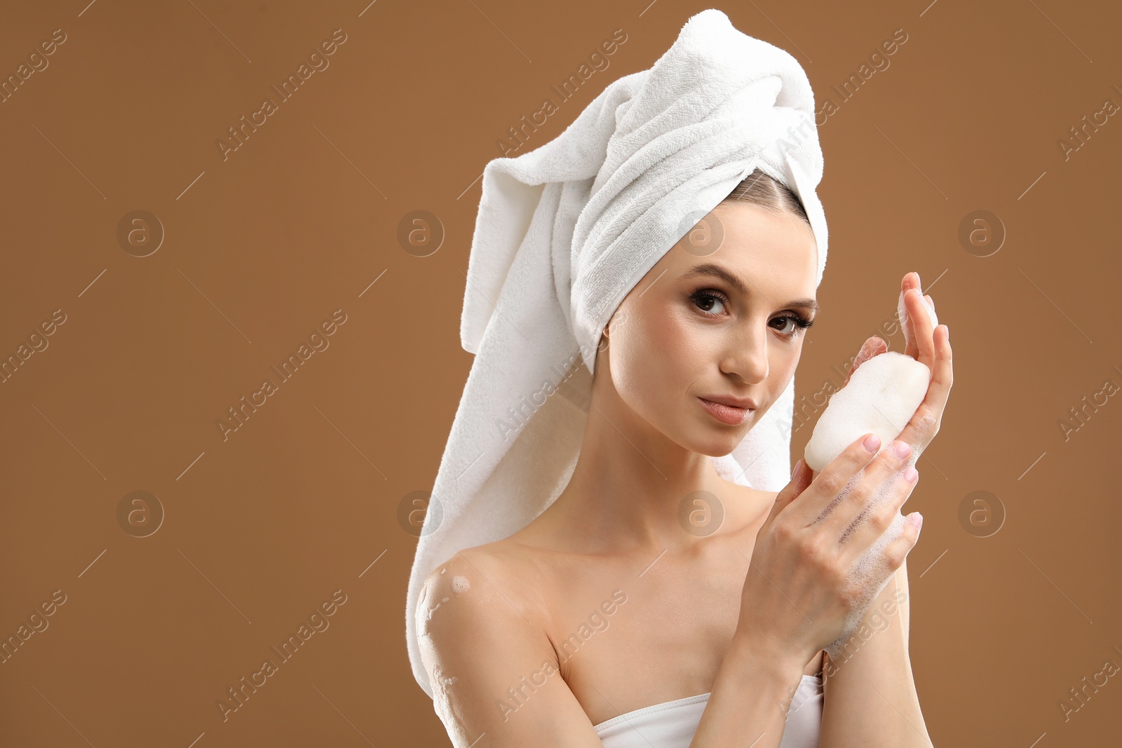 Beautiful woman with soap bar on brown background. Space for text Photo of Beautiful woman with soap bar on brown background. Space for text