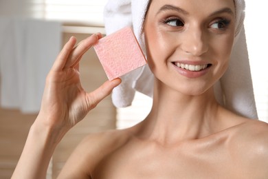 Photo of Smiling woman with soap bar indoors, closeup