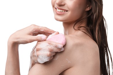 Photo of Smiling woman washing body with soap bar on white background, closeup
