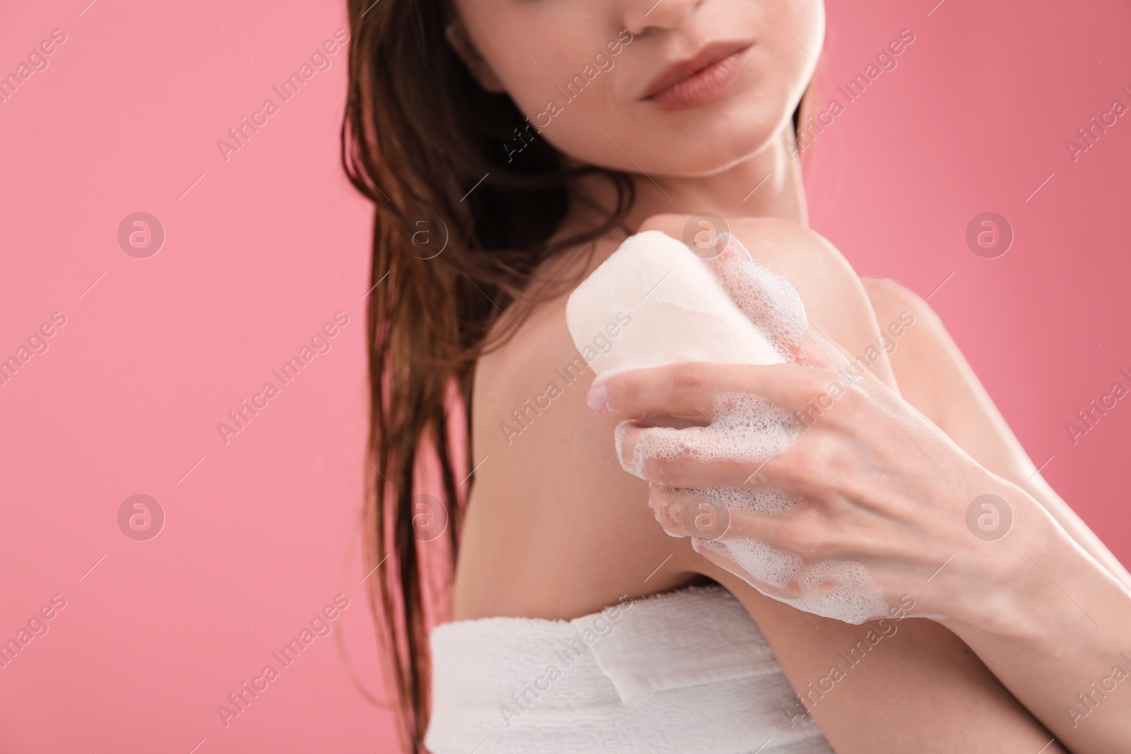 Woman washing body with soap bar on pink background, closeup Photo of Woman washing body with soap bar on pink background, closeup