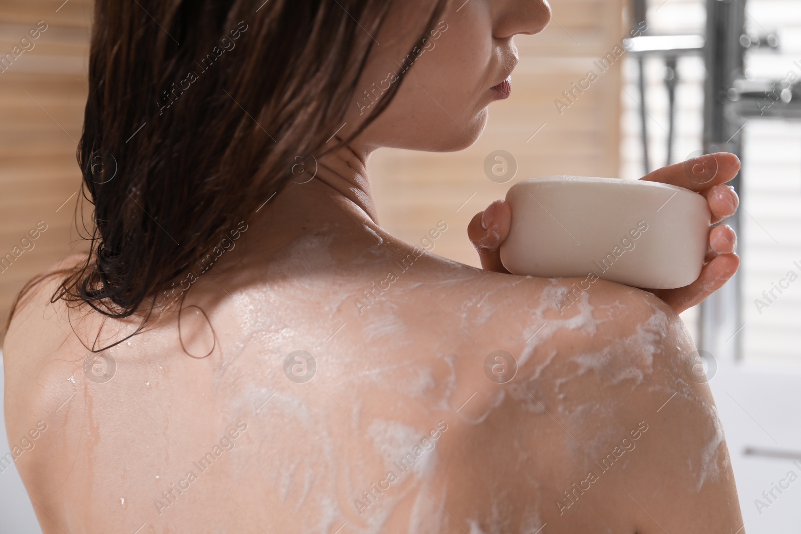 Woman washing body with soap bar in bathroom, closeup Photo of Woman washing body with soap bar in bathroom, closeup