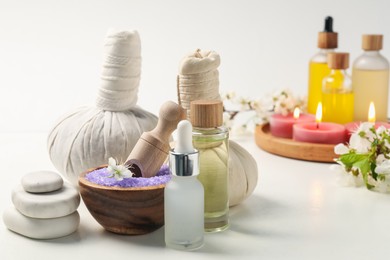 Photo of Spa composition with cosmetic products, beautiful flowers and burning candles on white background, selective focus