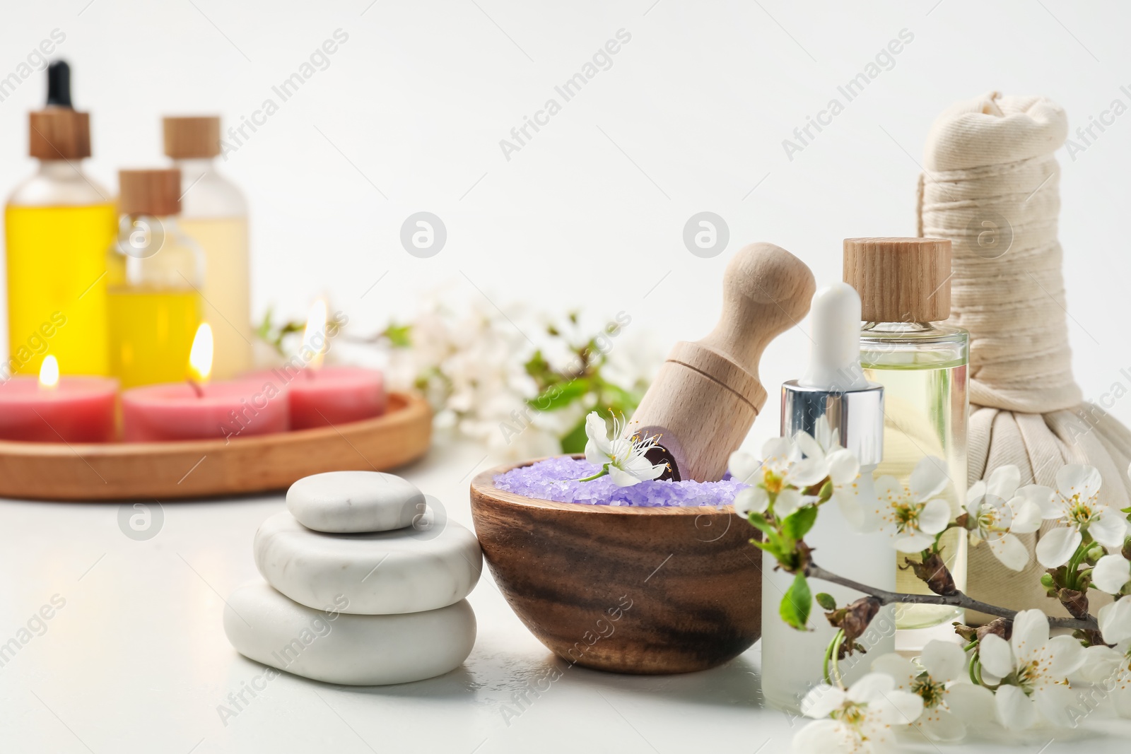 Spa composition with cosmetic products, beautiful flowers and burning candles on white background, selective focus Photo of Spa composition with cosmetic products, beautiful flowers and burning candles on white background, selective focus