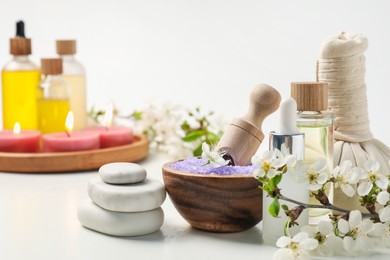Photo of Spa composition with cosmetic products, beautiful flowers and burning candles on white background, selective focus