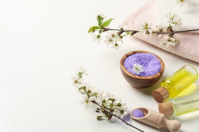 Photo of Spa products and twigs with beautiful flowers on white table. Space for text