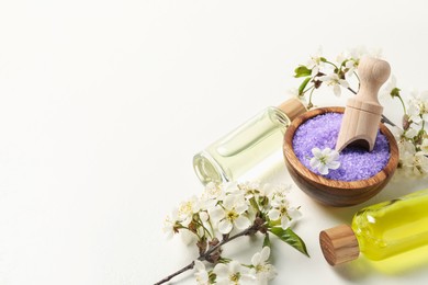 Photo of Spa products and twigs with beautiful flowers on white table. Space for text