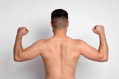Photo of Man after weight loss on light background, back view