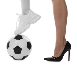 Photo of Woman in high heeled shoe and sneaker with soccer ball on white background, closeup