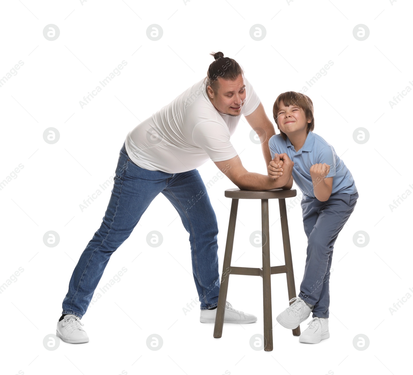 Father with his son arm wrestling on white background Photo of Father with his son arm wrestling on white background