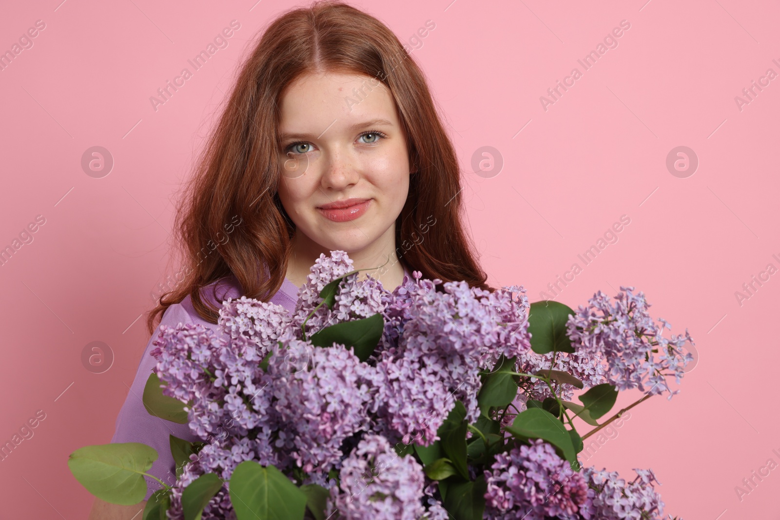 Portrait of beautiful teenage girl with lilac flowers on pink background Photo of Portrait of beautiful teenage girl with lilac flowers on pink background