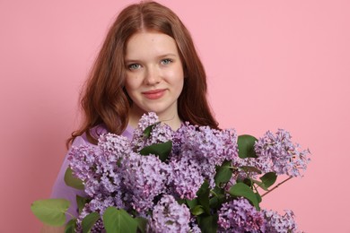 Photo of Portrait of beautiful teenage girl with lilac flowers on pink background