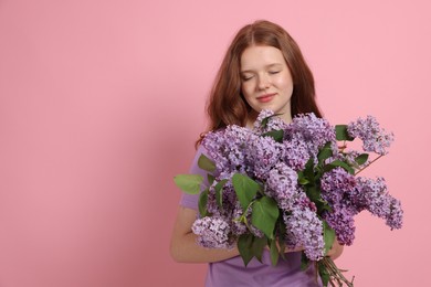 Photo of Beautiful teenage girl with bouquet of lilac flowers on pink background. Space for text