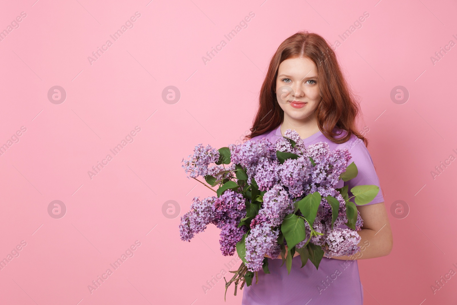 Beautiful teenage girl with bouquet of lilac flowers on pink background. Space for text Photo of Beautiful teenage girl with bouquet of lilac flowers on pink background. Space for text
