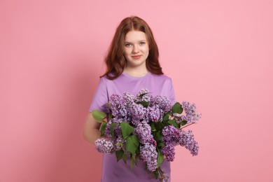 Photo of Portrait of beautiful teenage girl with lilac flowers on pink background