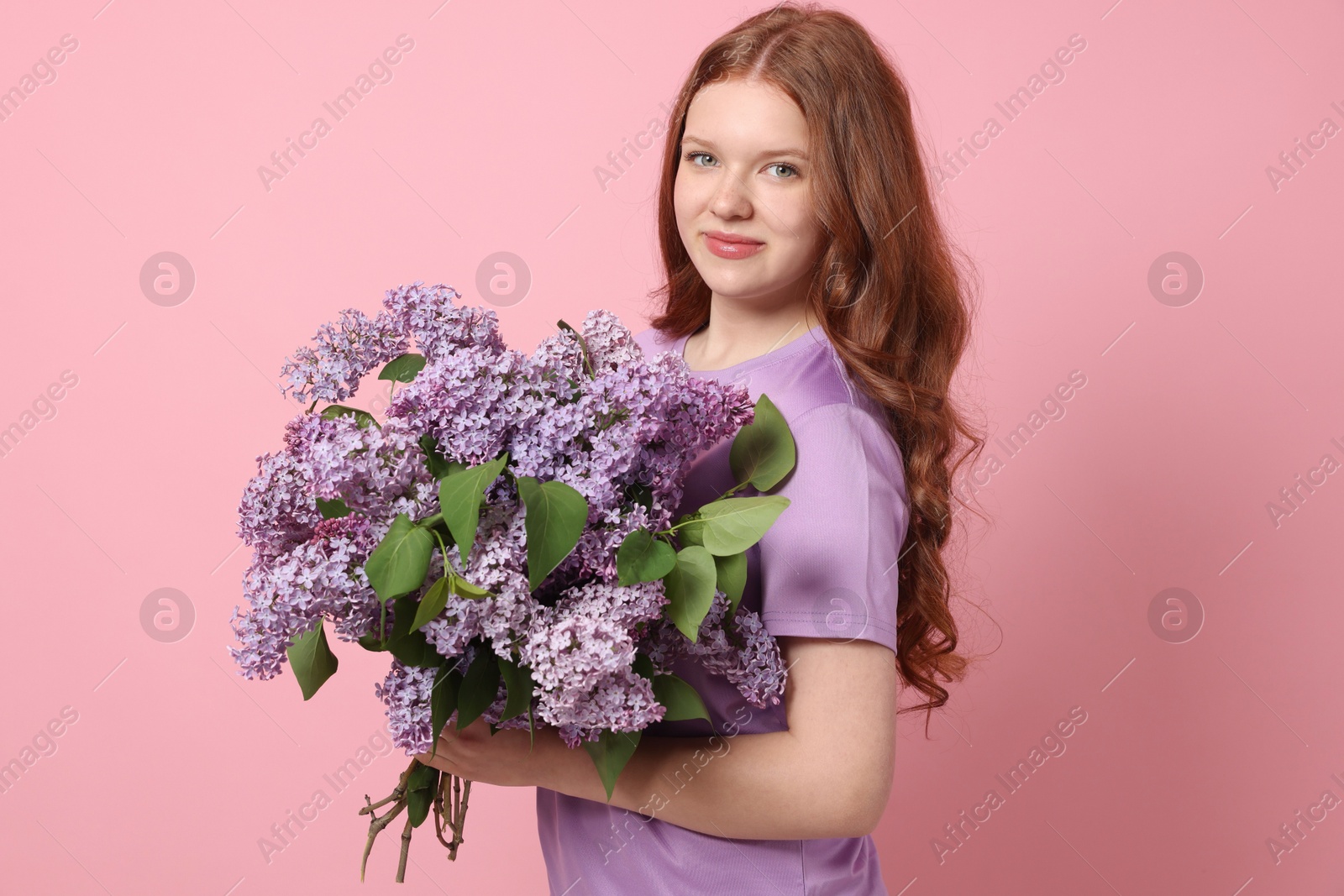 Portrait of beautiful teenage girl with lilac flowers on pink background Photo of Portrait of beautiful teenage girl with lilac flowers on pink background