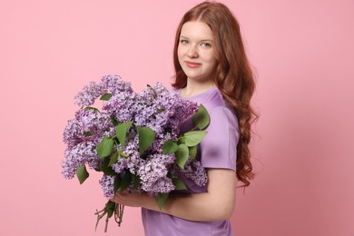 Photo of Portrait of beautiful teenage girl with lilac flowers on pink background