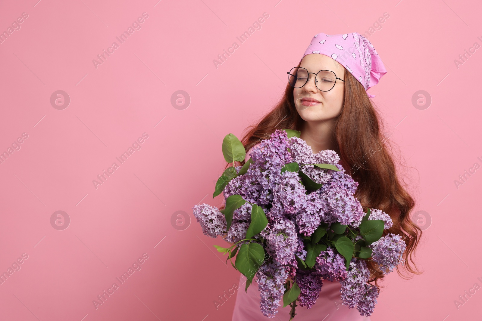 Beautiful teenage girl with bouquet of lilac flowers on pink background. Space for text Photo of Beautiful teenage girl with bouquet of lilac flowers on pink background. Space for text
