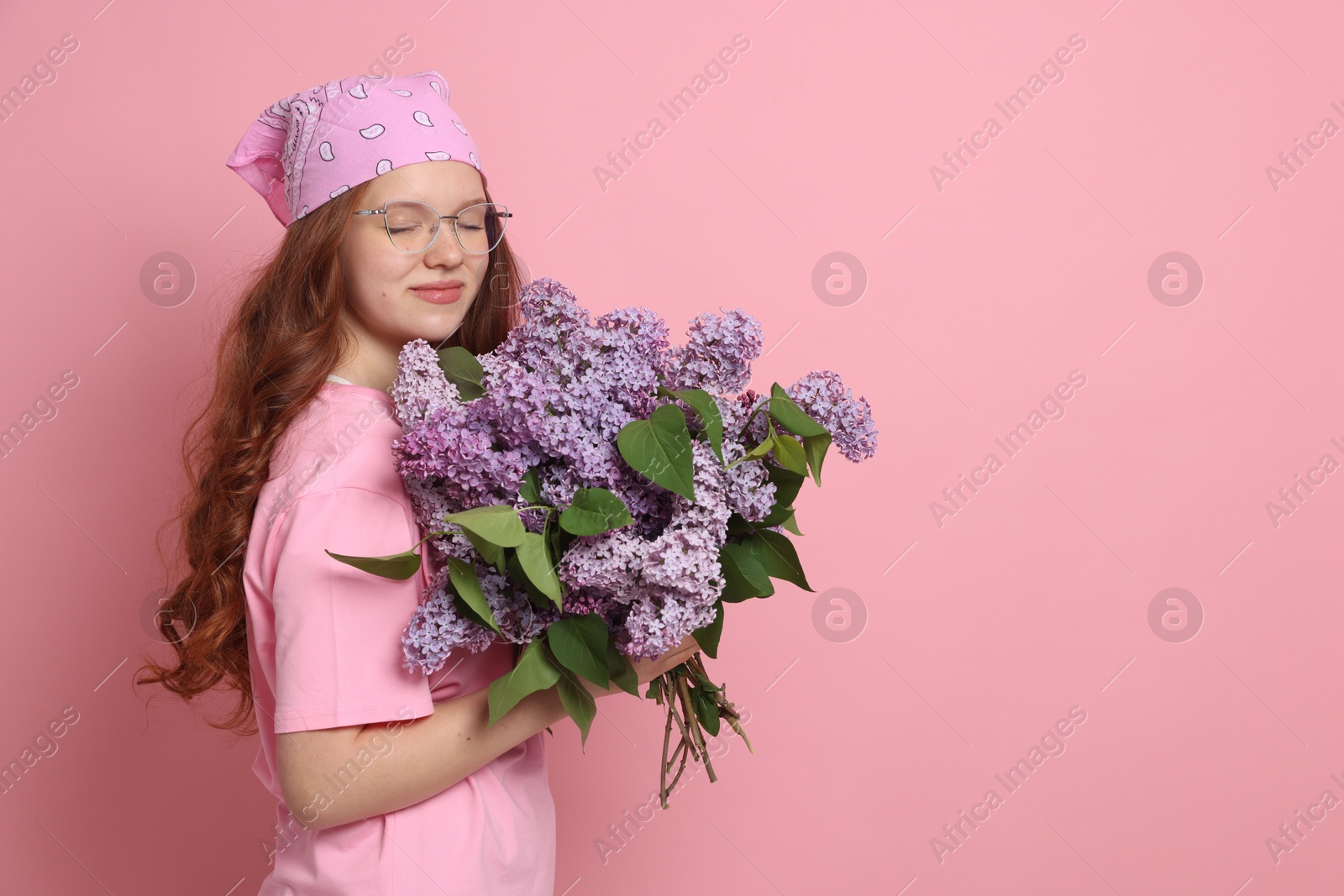Beautiful teenage girl with bouquet of lilac flowers on pink background. Space for text Photo of Beautiful teenage girl with bouquet of lilac flowers on pink background. Space for text