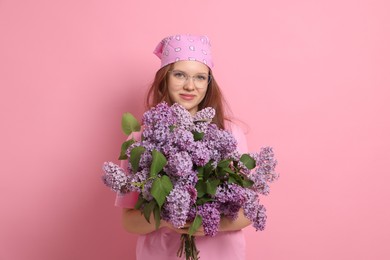 Photo of Portrait of beautiful teenage girl with lilac flowers on pink background