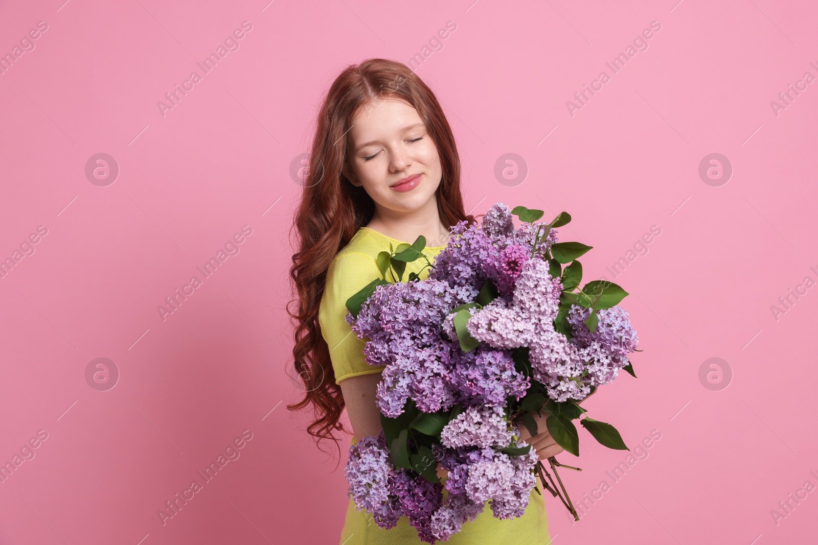 Portrait of beautiful teenage girl with lilac flowers on pink background Photo of Portrait of beautiful teenage girl with lilac flowers on pink background