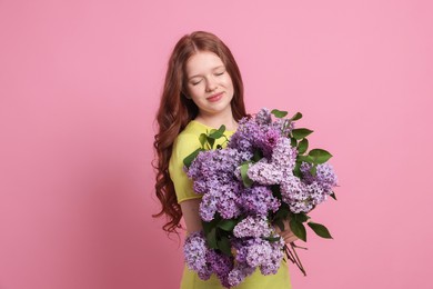 Photo of Portrait of beautiful teenage girl with lilac flowers on pink background