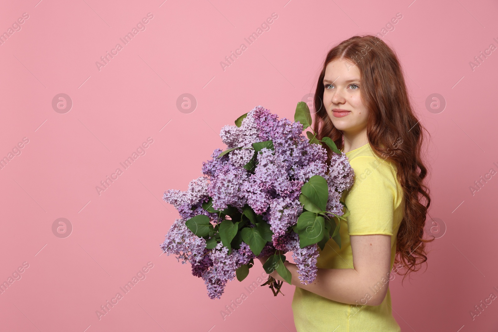 Beautiful teenage girl with bouquet of lilac flowers on pink background. Space for text Photo of Beautiful teenage girl with bouquet of lilac flowers on pink background. Space for text