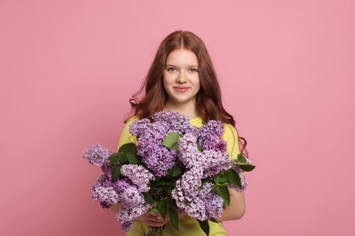 Photo of Portrait of beautiful teenage girl with lilac flowers on pink background