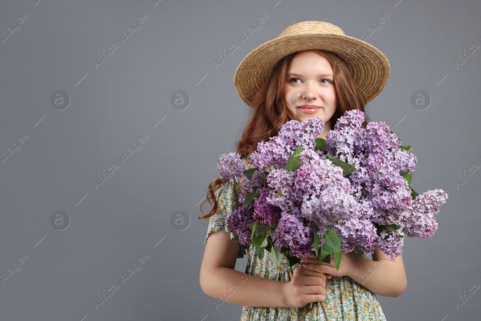 Beautiful teenage girl with bouquet of lilac flowers on grey background. Space for text Photo of Beautiful teenage girl with bouquet of lilac flowers on grey background. Space for text