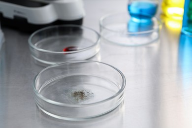 Photo of Petri dishes with samples on metal table, closeup