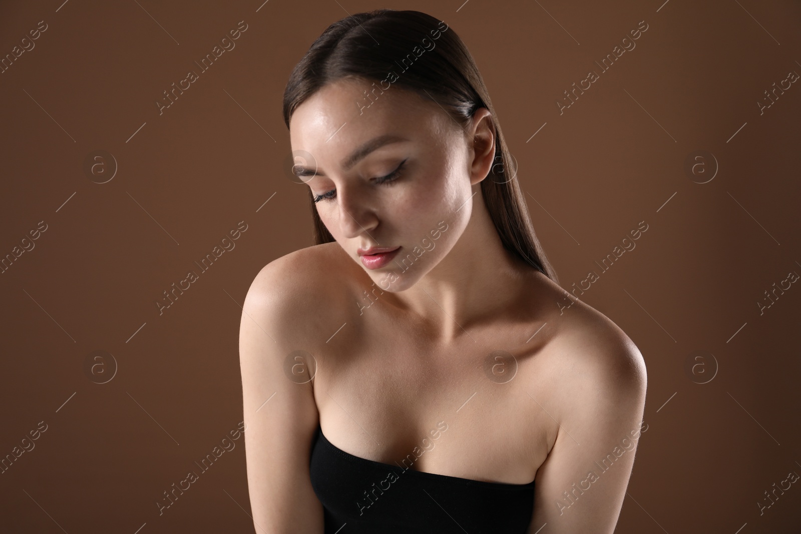 Woman with beautiful collarbones on brown background Photo of Woman with beautiful collarbones on brown background