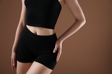 Photo of Attractive woman against brown background, closeup on belly