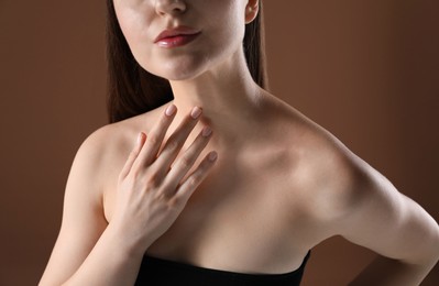 Photo of Woman with beautiful collarbones on brown background, closeup