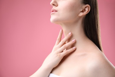Photo of Woman with beautiful collarbones and neck on pink background, closeup. Space for text