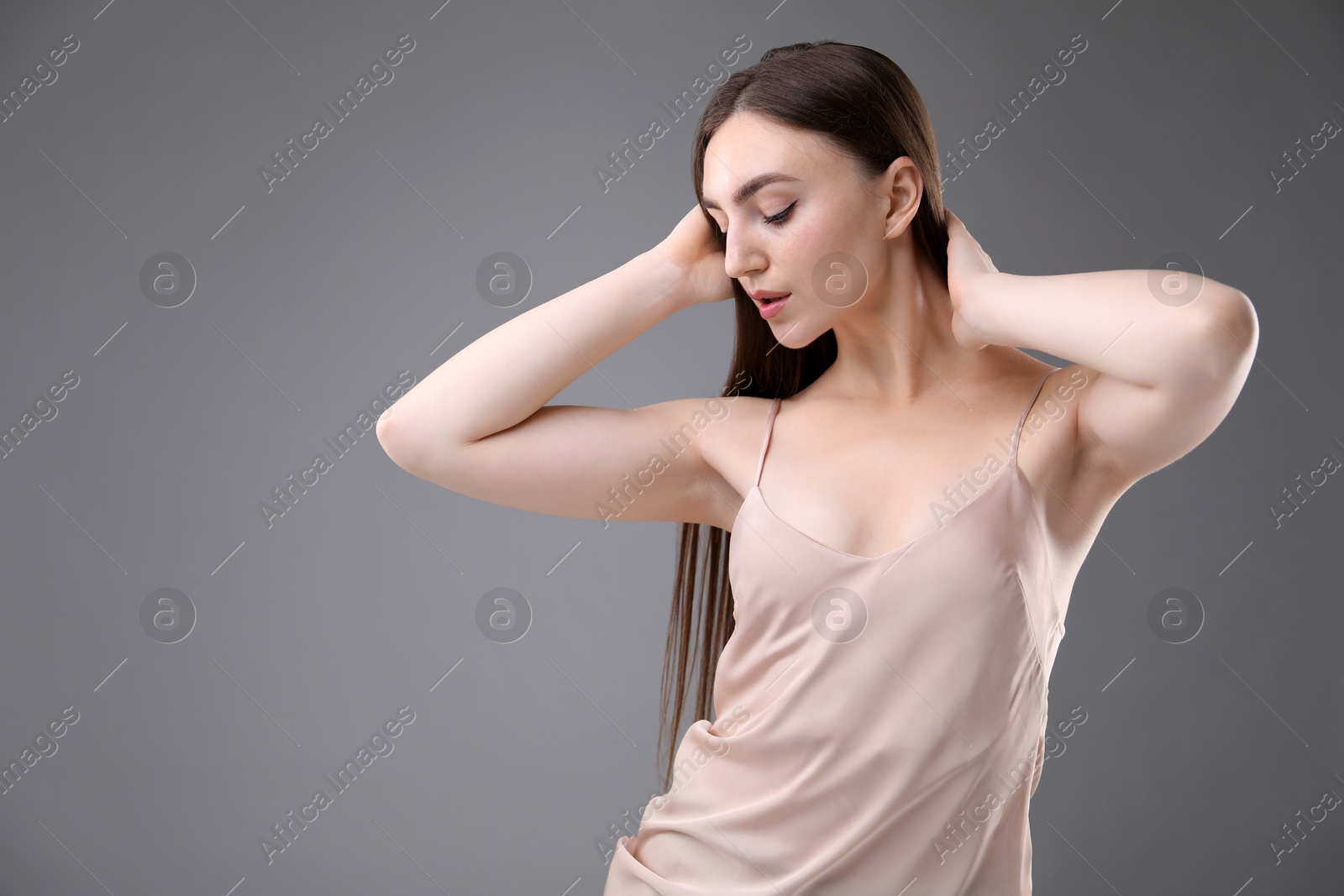 Portrait of beautiful woman on grey background Photo of Portrait of beautiful woman on grey background