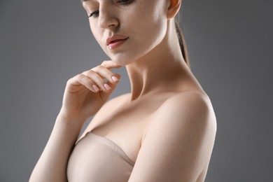 Photo of Attractive woman against grey background, closeup on shoulder