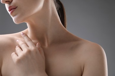 Photo of Woman with beautiful collarbones and neck on grey background, closeup