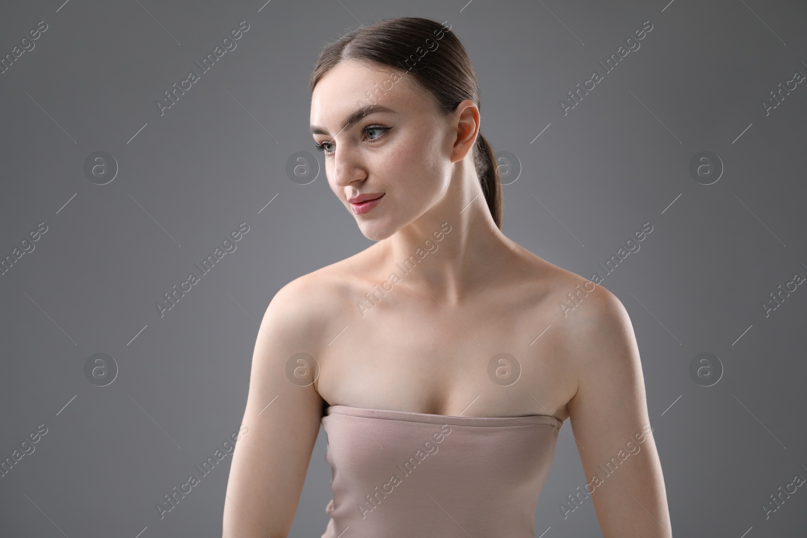 Portrait of beautiful woman on grey background Photo of Portrait of beautiful woman on grey background