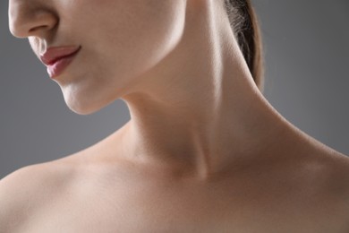 Photo of Woman with beautiful collarbones and neck on grey background, closeup