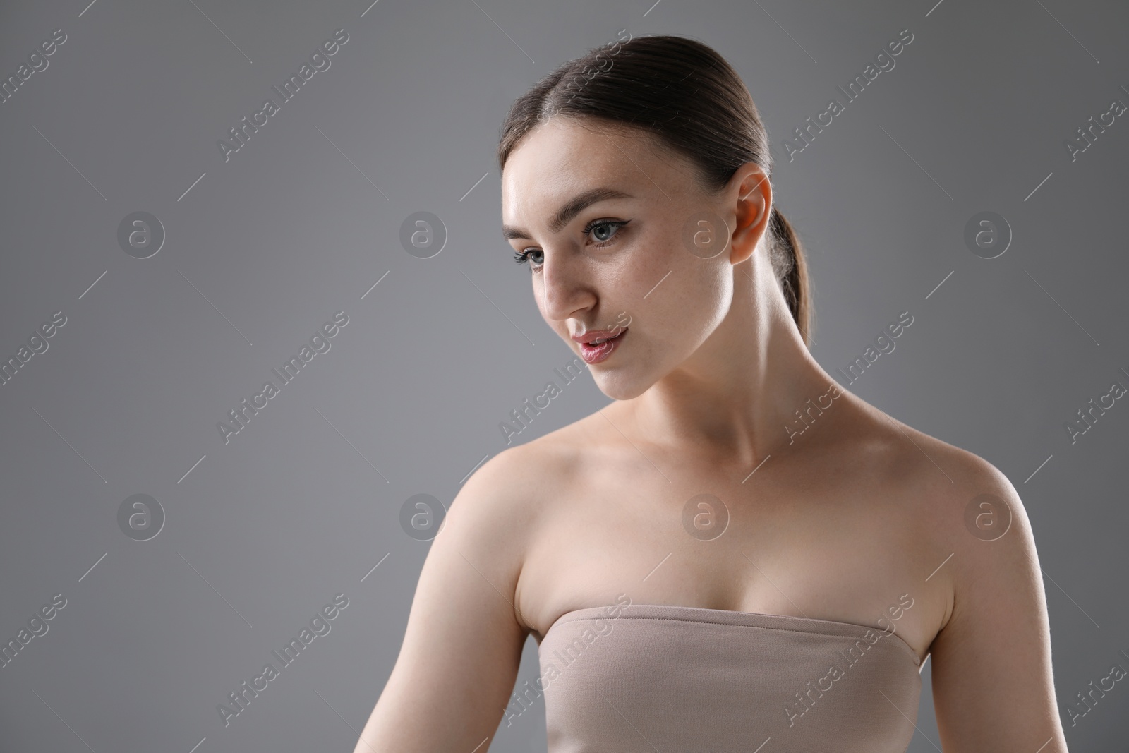 Portrait of beautiful woman on grey background. Space for text Photo of Portrait of beautiful woman on grey background. Space for text