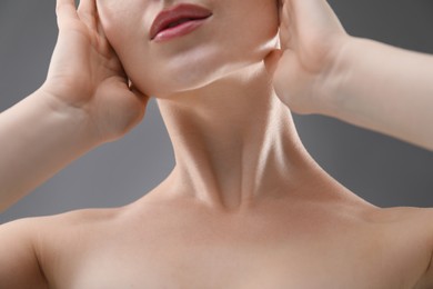Photo of Woman with beautiful collarbones and neck on grey background, closeup