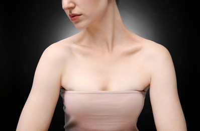Photo of Woman with beautiful collarbones and neck on black background, closeup