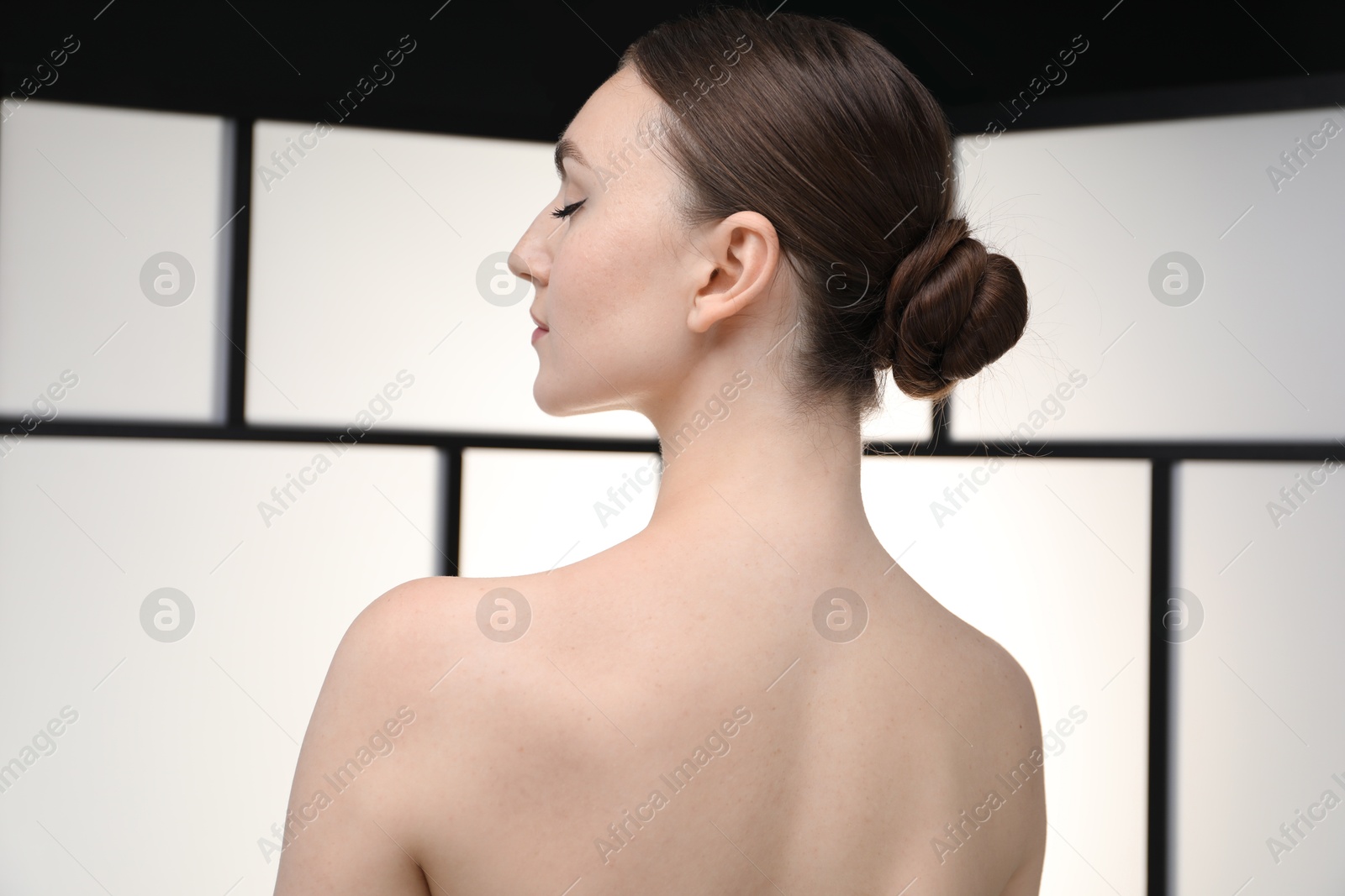 Beautiful woman on light background, back view Photo of Beautiful woman on light background, back view