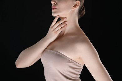 Photo of Woman with beautiful collarbones and neck on black background, closeup
