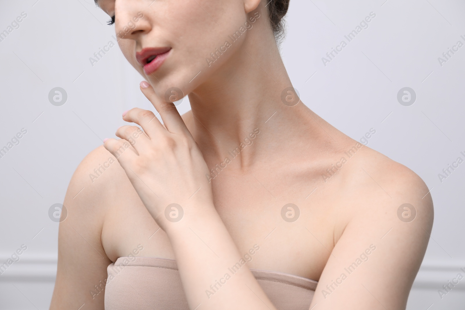 Woman with beautiful collarbones and neck on light background, closeup Photo of Woman with beautiful collarbones and neck on light background, closeup