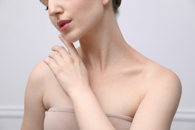 Photo of Woman with beautiful collarbones and neck on light background, closeup