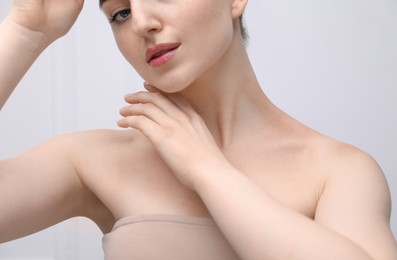 Photo of Woman with beautiful collarbones and neck on light background, closeup